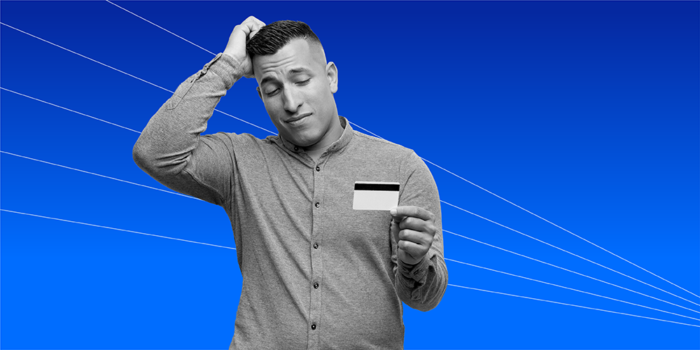 man scratching head and holding a credit card wondering does closing credit cards hurt your credit?