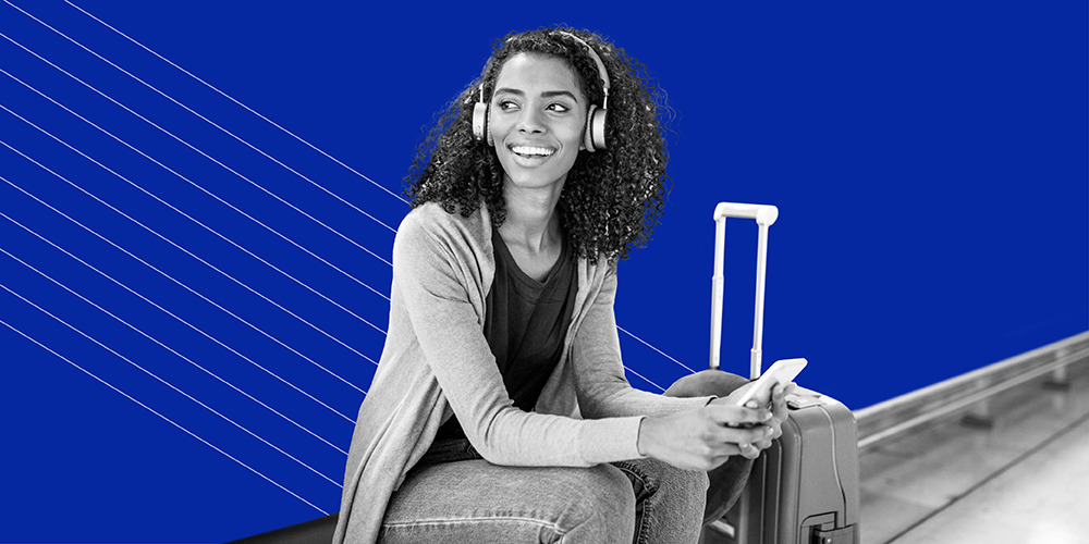 young woman wearing headphones with suitcase