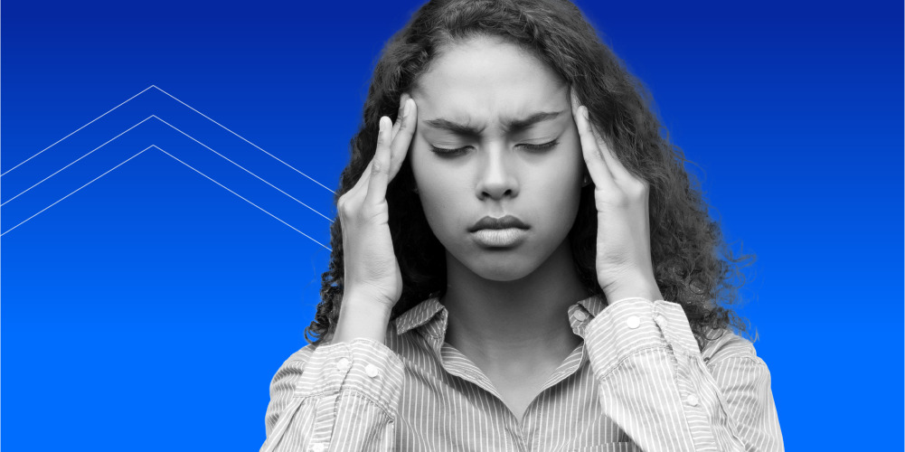 woman with curly hair holding her temples because she wants to know how to protect herself from phone scams