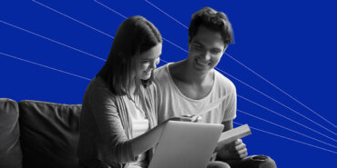 young couple reviewing a financial goals worksheet on the couch