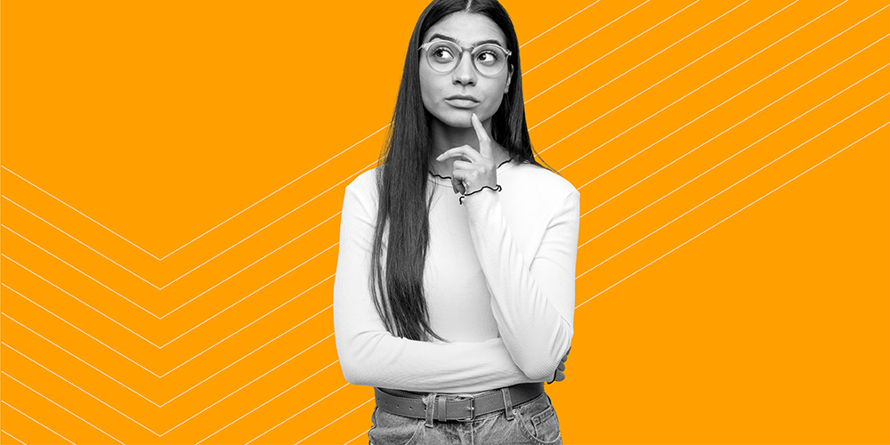 young woman with long hair and glasses wondering what is financial wellness?