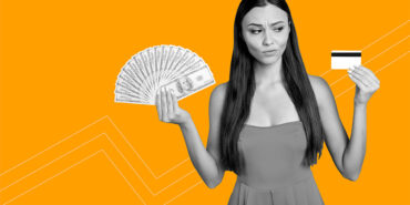 young woman holding money and a credit card asking should you use an installment loan to pay off your credit cards?