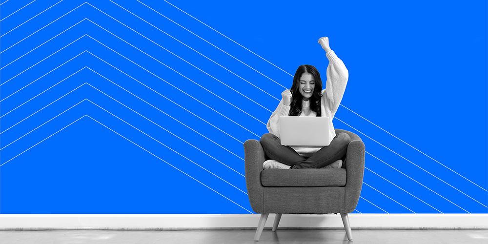 woman sitting cross legged in armchair celebrating after finding 5 of the best reward and cashback apps