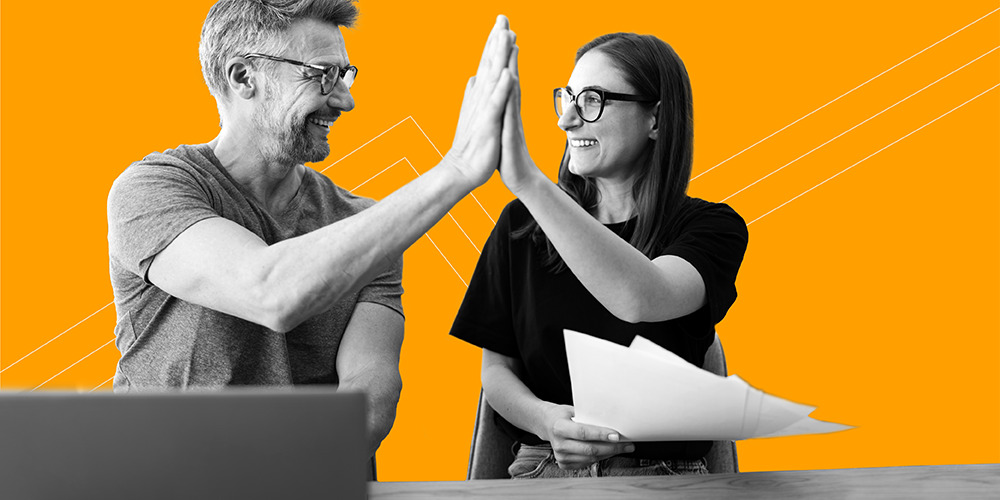 couple with glasses high fiving after learning to sweep away debt with a debt avalanche