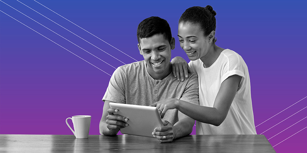 young couple smiling while sharing an iPad