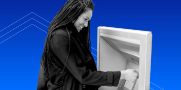 A smiling woman with long dark braids making a transaction at an ATM